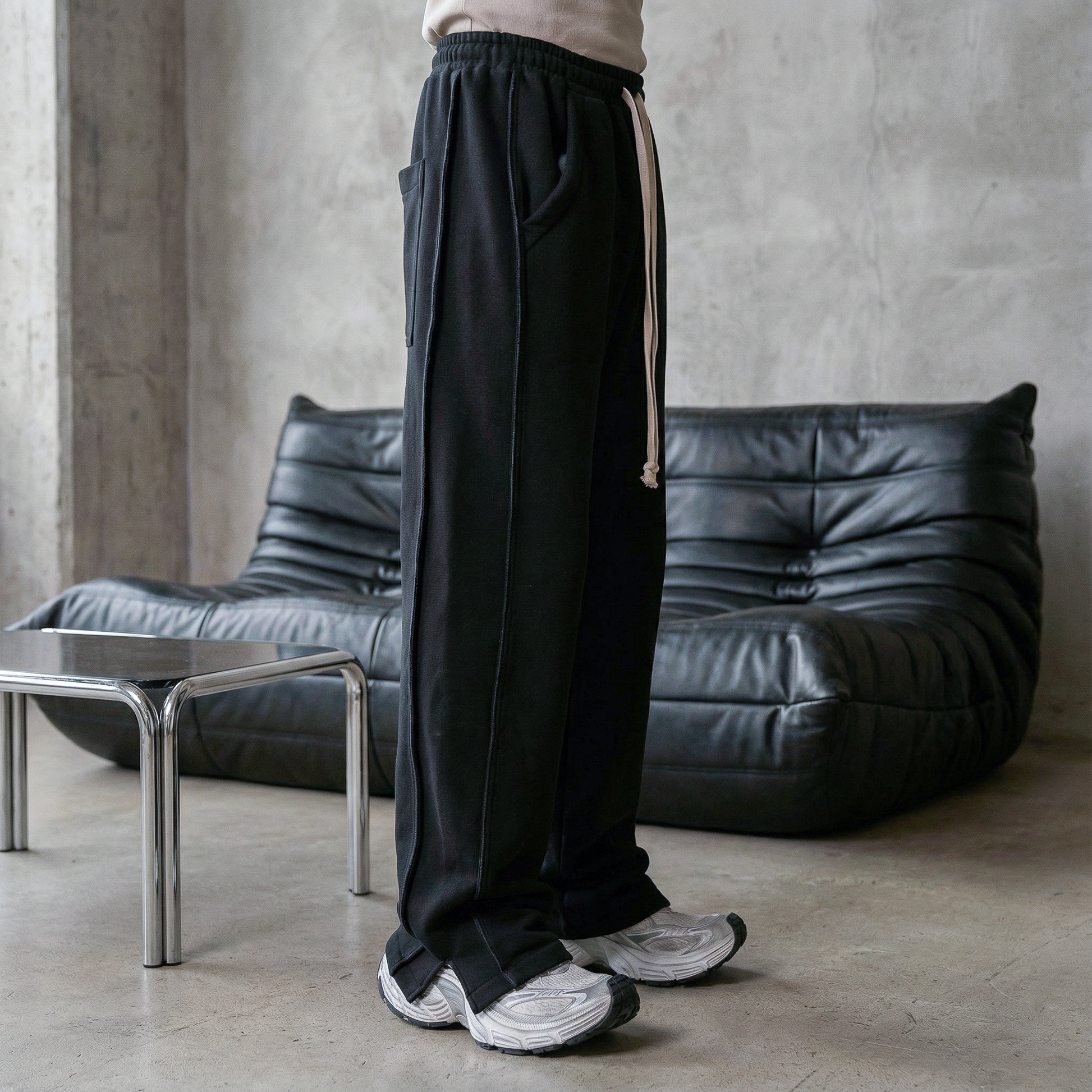 Minimalist streetwear editorial featuring a monochrome black outfit, modern menswear silhouette, subtle motion effect and luxury urban aesthetic, SS fashion collection.
